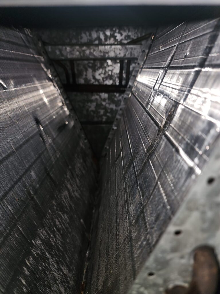 Clean air conditioning coils inside of a furnace plenum